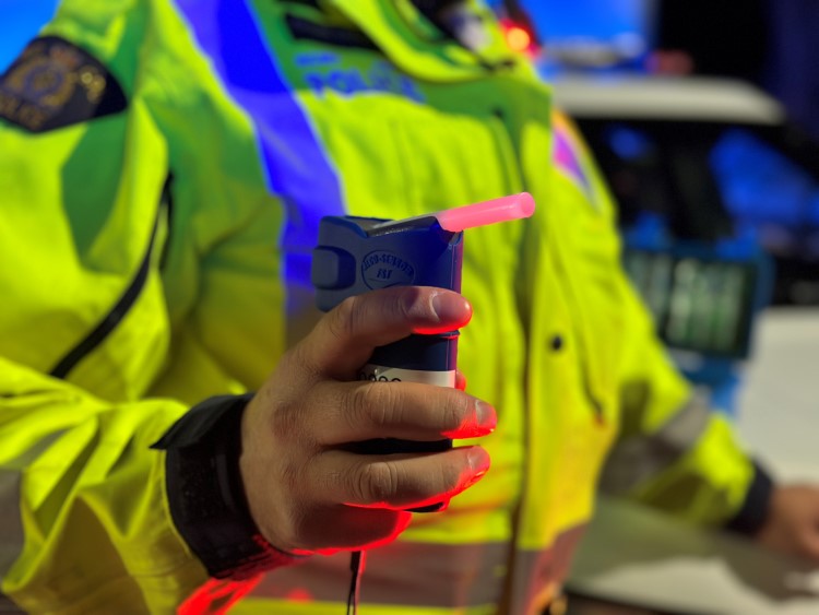 photo of an RCMP officer operating breathalyzer equipment roadside