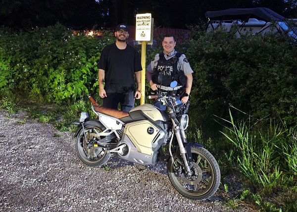Owner, Atharva Sangani and Constable Scott Shaw with the returned stolen electric motorcycle