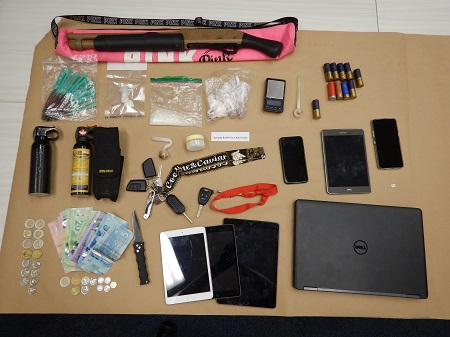 table full of weapons, drugs and money