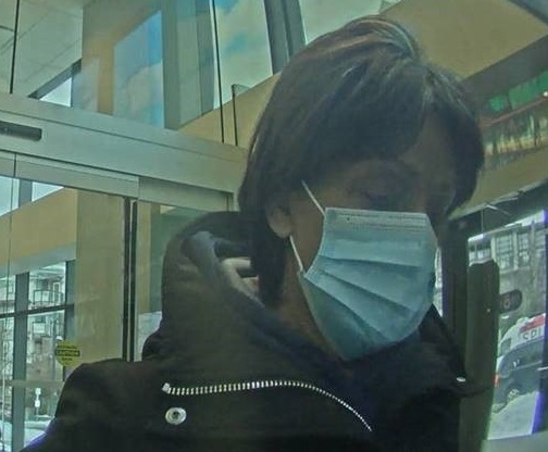 woman with dark hair, wearing a blue face mask