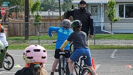 A Community Service Officer demonstrates a hand signal during a recent school bike rodeo.  