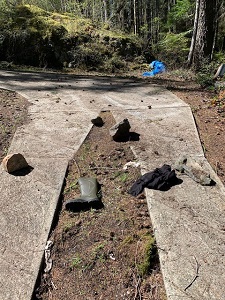Green boot and various clothing strewn on ground