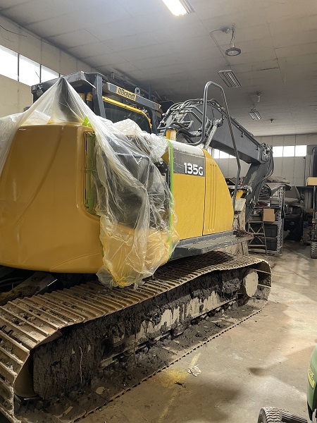 Large yellow Excavator inside a very large shed