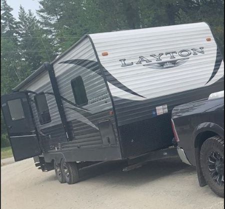 Une caravane classique Layton grise et blanche attachée à un camion.