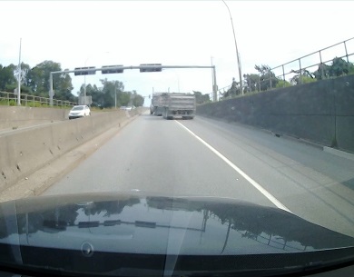 Vue arrière du camion à benne franchissant la ligne continue de droite à gauche