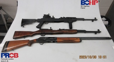 Un fusil de chasse et deux carabines sont présentés sur un fond blanc
