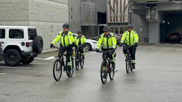 Four Surrey RCMP officers with our Mobile Street Enforcement Team (MSET) doing bike patrols through a mall parking lot.