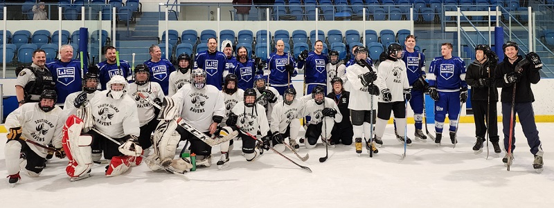 group photo of hockey players in white and blue on an ice rink