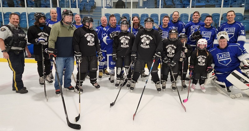 groupe de joueurs de hockey en noir et bleu posant sur une patinoire