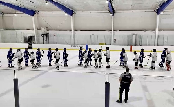 two hockey teams lining up to shake hands on the ice